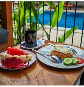 una mesa con dos platos de comida y una taza de café en Abdi Hotel, en Gili Trawangan