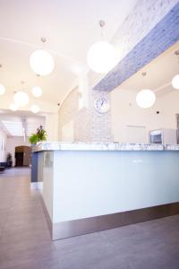 an office lobby with a white counter and a clock at Adeba Hotel in Prague
