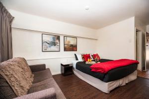 una camera da letto con un letto e un divano di Motel Oasis a Kingaroy