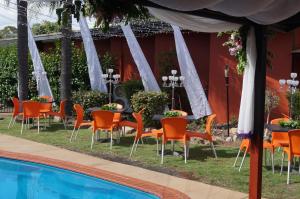 a group of tables and chairs next to a pool at Motel Oasis in Kingaroy