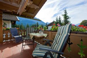 Un patio con una mesa y sillas en un balcón. en Ferienhaus Alpenzauber, en Krün