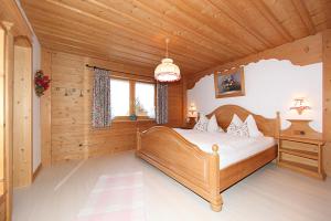 Un dormitorio con una cama en una habitación de madera. en Ferienhaus Alpenzauber, en Krün