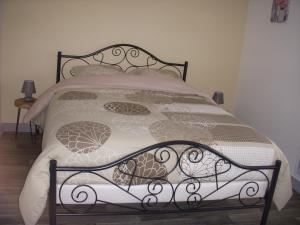 uma cama com uma armação de metal e almofadas em Les Peupliers em Vesly