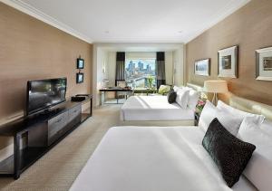a hotel room with two beds and a flat screen tv at Crown Towers Melbourne in Melbourne