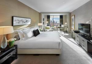 a large hotel room with a bed and a television at Crown Towers Melbourne in Melbourne