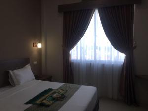 En eller flere senge i et værelse på Bunda Hotel Padang - Halal Hotel