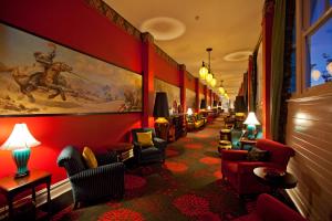 a long corridor of a bar with red walls and chairs at Hydro Majestic Blue Mountains in Medlow Bath