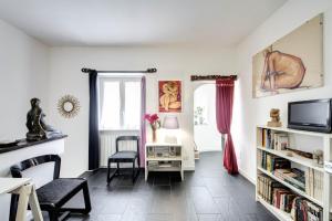 ローマにあるRhome Apartments Leoninaのリビングルーム(テレビ、椅子、テーブル付)