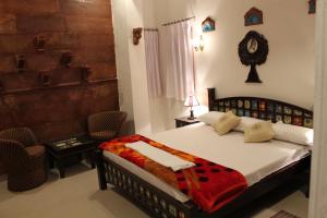 a bedroom with a bed and a table and a chair at Karma Heritage Guest House in Jodhpur