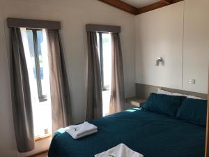 a bedroom with a blue bed and two windows at Great Western Motel in Great Western