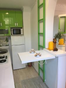 a kitchen with green cabinets and a white counter top at Apartment Bombonyerka in Drogobych