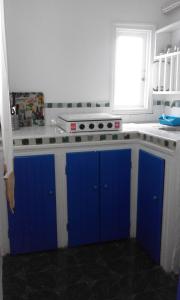a kitchen with blue and white cabinets and a window at Pilar Ruiz in Asilah