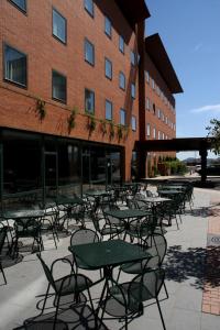 a group of tables and chairs in front of a building at Posadas De España Cartagena in Cartagena