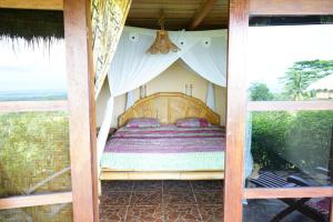 een slaapkamer met een bed in een tent bij Rinjani Mountain Garden in Bayan