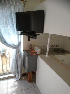 a kitchen with a flat screen tv on the wall at Chanelle Self Catering in Bloemfontein