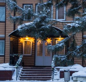 a house with christmas lights in the snow at парк-отель "Хамовники" in Tersa