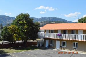 un edificio con un árbol delante de un aparcamiento en Western Traveller Motel, en Grand Forks