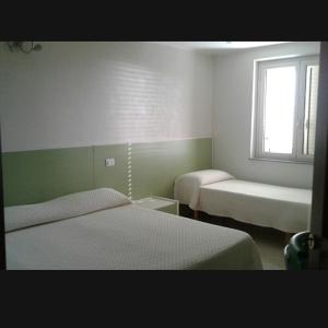 a hotel room with two beds and a window at Sweet Home in Falerna