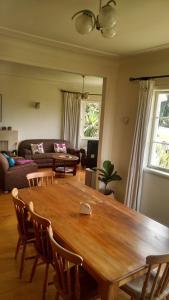 sala de estar con mesa de madera y sillas en Kiwi Heritage Homestay, en Auckland