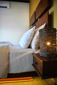 a bedroom with a bed with white pillows and a night stand at The Canoe in Negombo