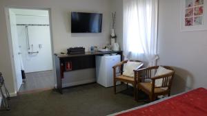 um quarto com um frigorífico e uma mesa com 2 cadeiras em Bridgetown Valley Lodge em Bridgetown