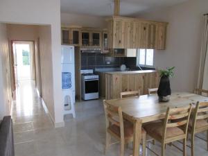 a kitchen with a wooden table and a table and chairs at Villa Mambo in Patrana