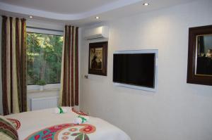 a hotel room with a television on the wall at Jurata Dzikie Wino in Jurata