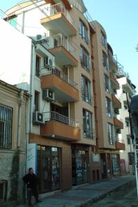 a man walking down a street in front of a building at TOP CENTER , MODERN AND QUIET APARTMENT in Burgas