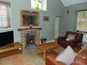 a living room with a fireplace and a tv at Everley Cottage in Scarborough