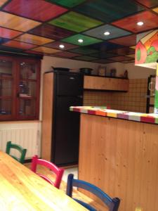 Una cocina con una mesa de madera y una barra con sillas. en Princesse Galetas, en Saint-Étienne-de-Tinée