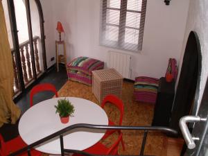 sala de estar con mesa blanca y sillas rojas en Princesse Galetas, en Saint-Étienne-de-Tinée