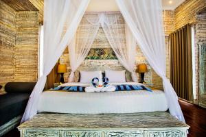 a bedroom with a canopy bed with a teddy bear on it at The Palm Grove Villas - CHSE Certified in Nusa Lembongan