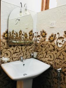 Treasure House Tourist Rest في أنورادابورا: حمام مع حوض أبيض ومرآة