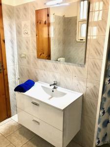 トッレ・サン・ジョヴァンニ・ウジェントにあるVilletta Sabbia d'Oroのバスルーム(白い洗面台、鏡付)