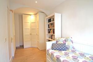 a living room with a chair and a book shelf at Apartamento Vacacions Felanitx in Felanitx