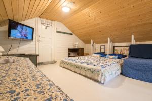 a bedroom with two beds and a flat screen tv at Oak House in Naantali