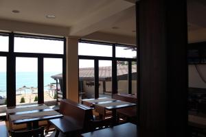 a restaurant with tables and chairs and a view of the ocean at Family Hotel Piter in Golden Sands