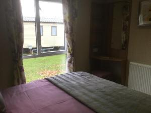 a bedroom with a bed in front of a window at Tattershall lakes in Tattershall