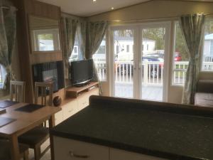 a kitchen with a television and a table with a table sidx sidx sidx at Tattershall lakes in Tattershall