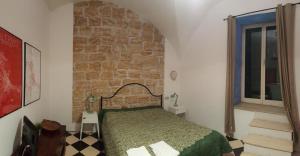 パレルモにあるCalamarùのレンガの壁、ベッド付きのベッドルーム1室