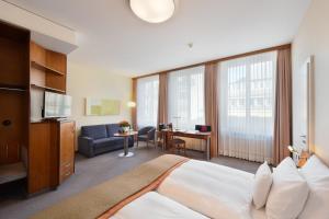 una camera d'albergo con un grande letto e un soggiorno di Glärnischhof by TRINITY a Zurigo