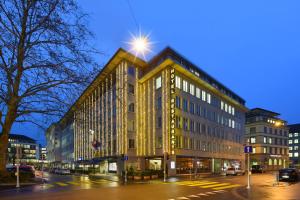 ein großes Gebäude in der Nacht auf einer Stadtstraße in der Unterkunft Glärnischhof by TRINITY in Zürich