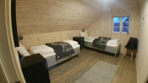 ヘニングスヴァールにあるLysvoldbryggaの木製の壁の小さな部屋のベッド2台