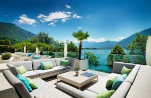 a living room with a view of a lake and mountains at Giardino Lago in Locarno