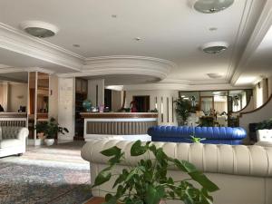 un soggiorno con mobili bianchi e un divano blu di Mondial Park Hotel a Fiuggi