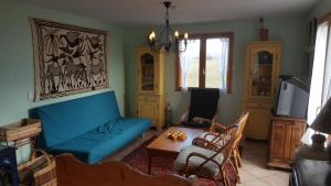 a living room with a blue couch and a table at Maison Vinzier in Vinzier