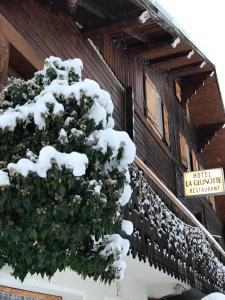 uma árvore coberta de neve no lado de um edifício em La Gelinotte em Les Contamines-Montjoie