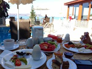 a table with plates of food on a table near a pool at Medusa Hotel in Kas