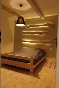 Bett in einem Zimmer mit einer Lampe an der Wand in der Unterkunft Apartamenty We Młynie in Warpuny