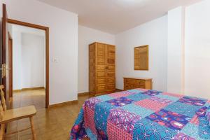 1 dormitorio con cama, mesa y cómoda en Vivienda Vacacional El Faro, en Puerto Naos, en Los Llanos de Aridane